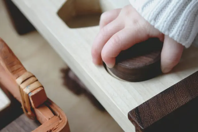 Kinderhand op een houten kindermeubel